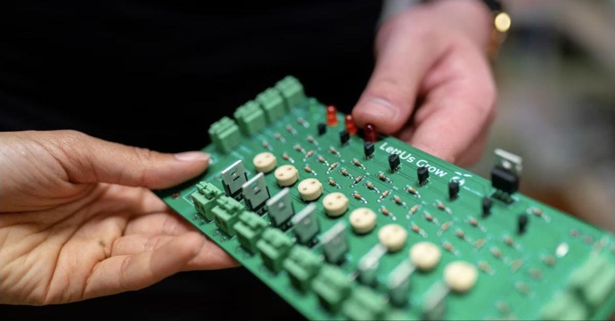 Engineers examining a printed circuit board prototype